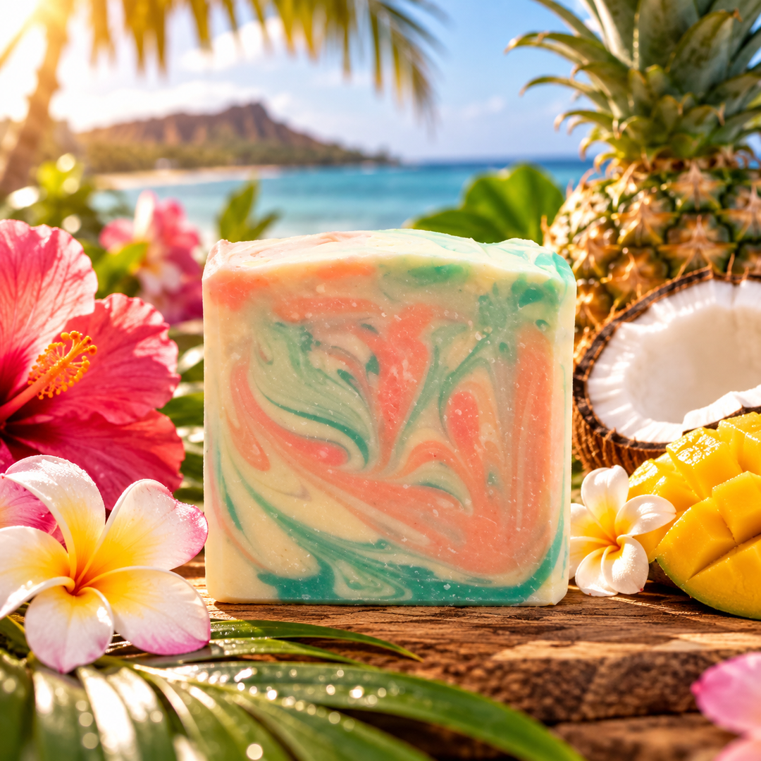 Aloha! handmade goat milk soap by Always Bubbles, featuring tropical coral pink, seafoam green, and creamy ivory swirls, displayed with hibiscus flowers, plumeria blossoms, pineapple, coconut, and fresh mango against a beautiful Hawaiian beach backdrop.