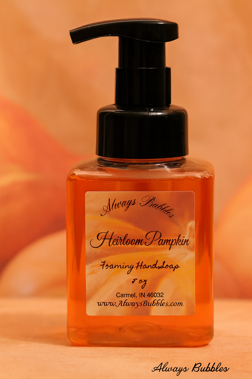 Always Bubbles Heirloom Pumpkin Foaming Hand Soap in square clear bottle with warm amber pumpkin-colored soap and cozy autumn background