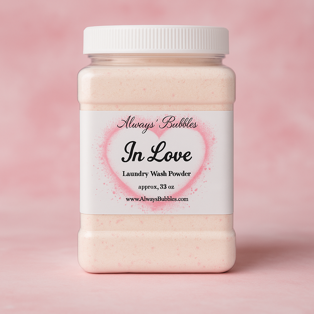 Always Bubbles ‘In Love’ 32 oz laundry wash powder in a clear plastic jar with a pink heart label, displayed against a soft pink scent-themed background.